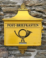 alter gelber Briefkasten an Natursteinmauer